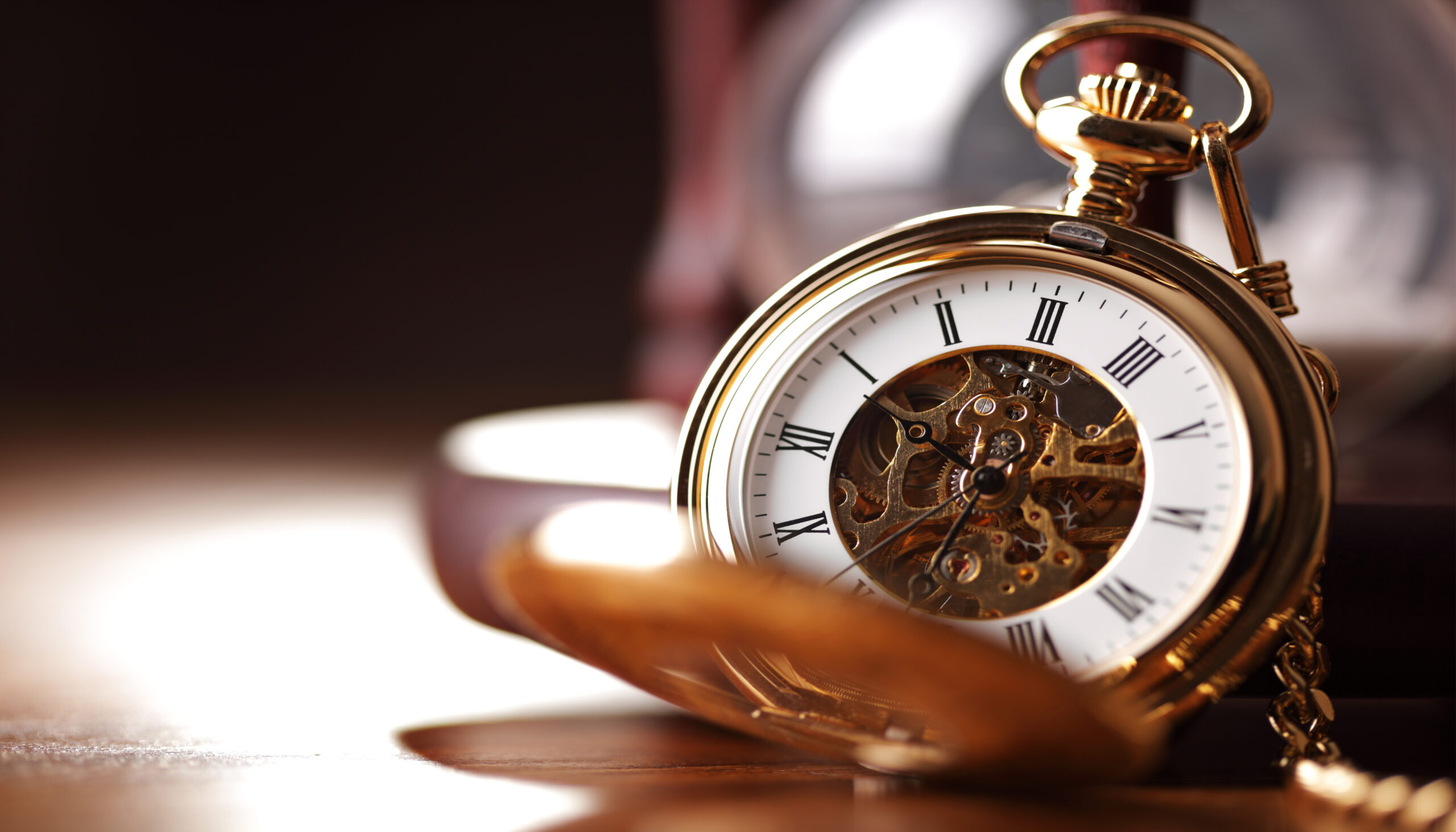 Goldene Taschenuhr neben einer Sanduhr